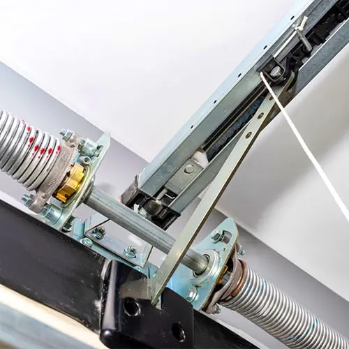 Close view of a residential garage door torsion spring and lifting hardware